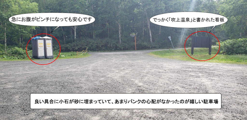 吹上温泉の砂利が敷かれたのみの駐車場の様子。簡易トイレ2台と「吹上温泉」と書かれた大きな看板が一つ設置されている。